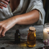 A woman's arm, a candle, and aromatherapy oil